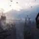 Birds fly over the ruins of a city as a person prepares to glide down to its streets.